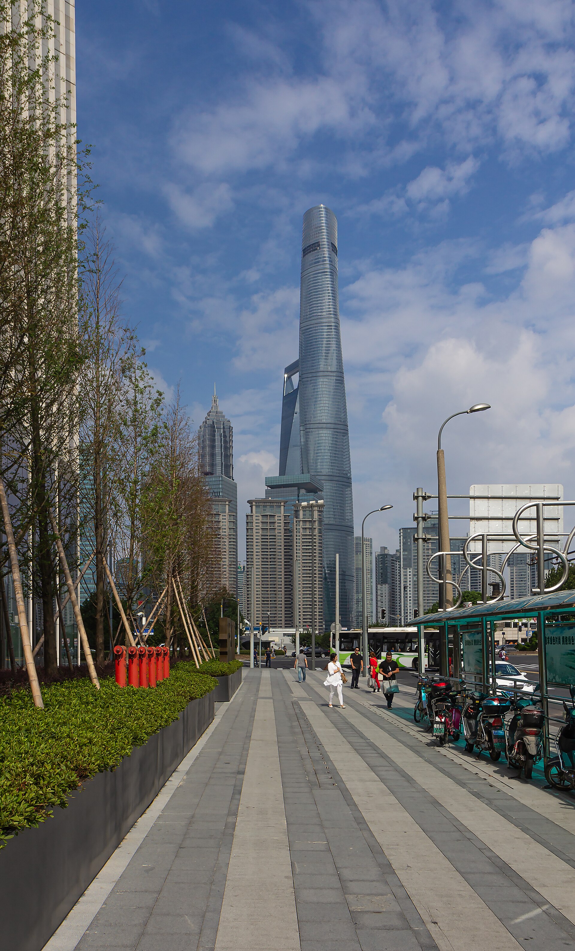 Shanghai Tower seen from Xinkaihe Road, above a tree-lined street, in September 2016.