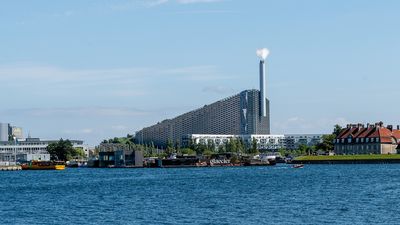 CopenHill’s sloping roof and smokestack rise beside the waterfront in Copenhagen.