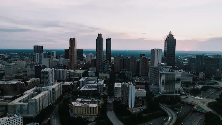 Illustrative photograph: atlanta skyline at dusk with roads and office towers.
