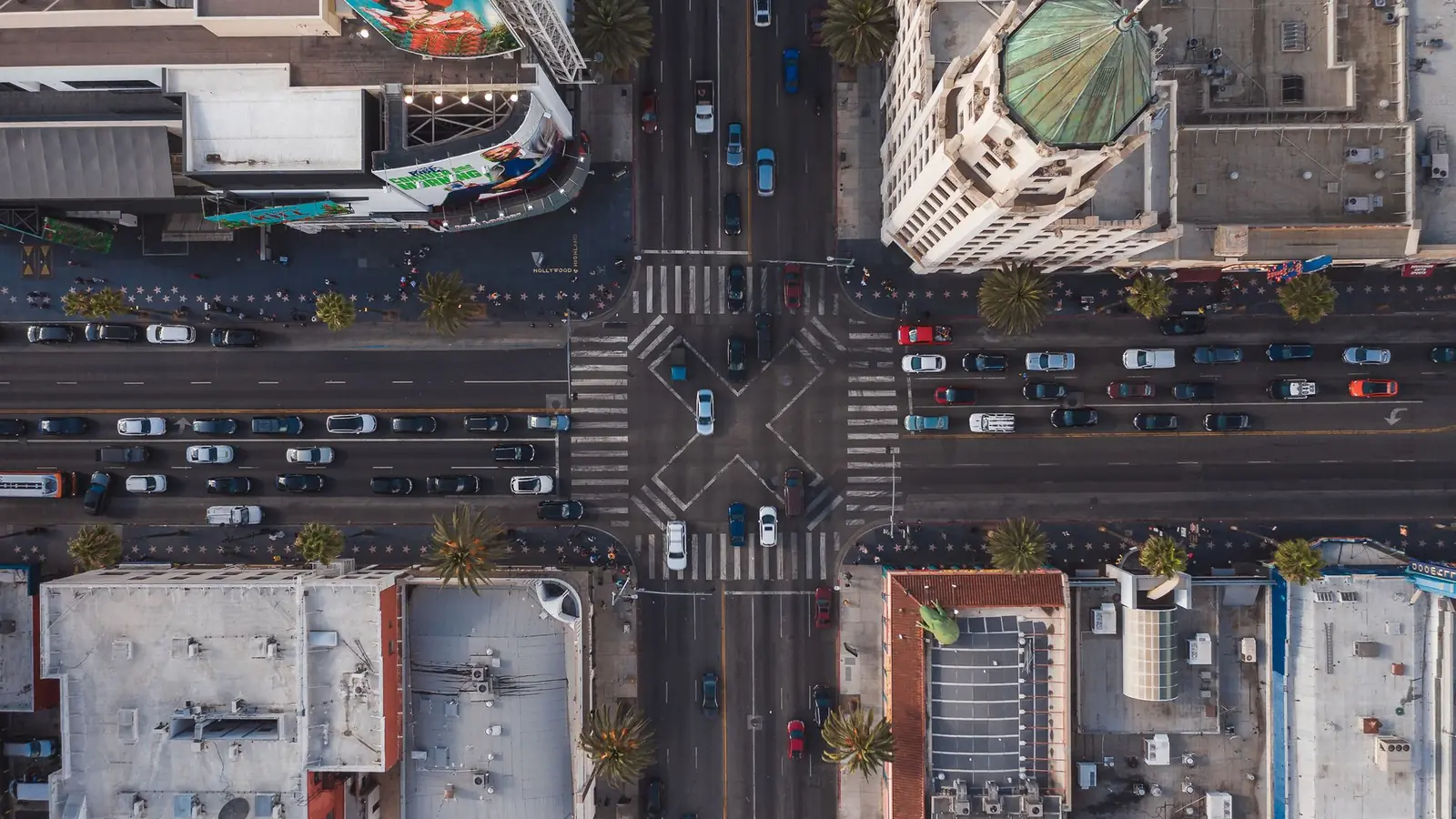 A four-way city intersection with traffic moving through coordinated traffic signals
